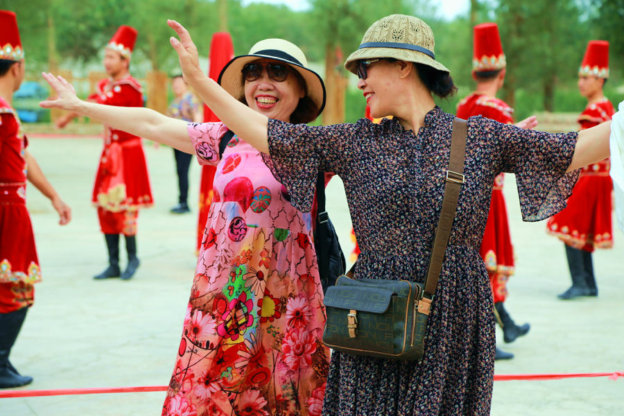 图为游客在刀郎部落开心舞蹈(包良廷 摄) 图为游客在刀郎部落开心舞蹈(包良廷 摄)