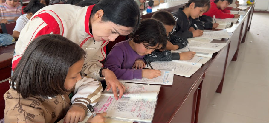 图为志愿者正在帮学生讲解作业难题（海立 摄）