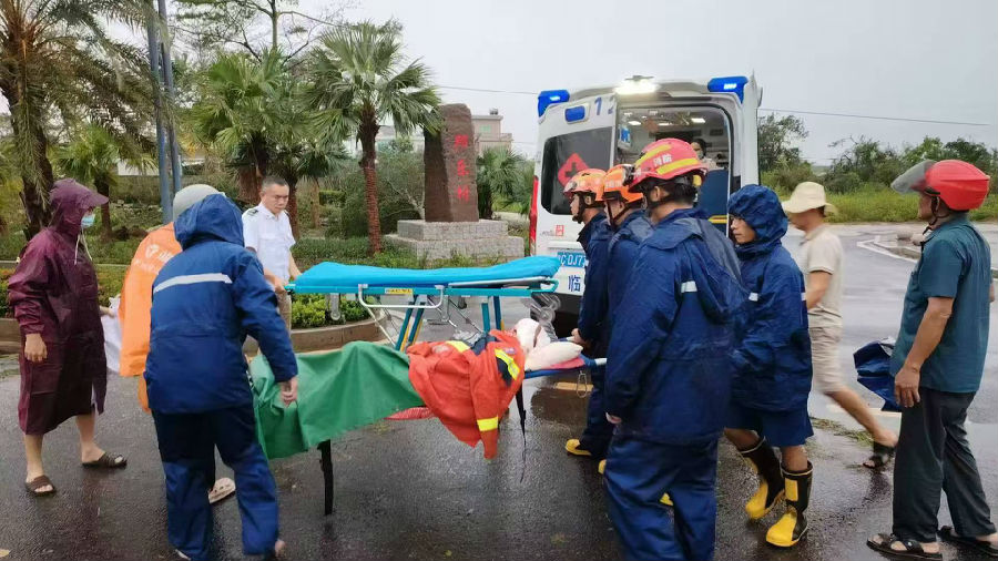 9月7日，临高消防紧急清障10公里后，步行2公里用担架将一名受伤老人成功转移至救护车上送医救治。（逄宇 摄）