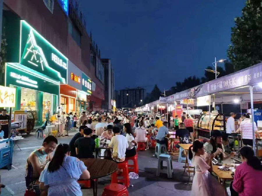 图为郧西县小河夜市人们三三两两相聚，吃着令人愉悦的美食（周晓红 摄）