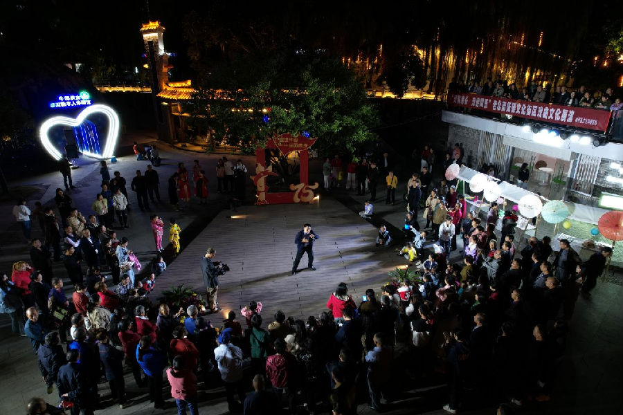 图为郧西县老北街绿色低碳文化街区的“戏韵悠长·戏迷同乐”活动吸引游客驻足听戏（周晓红 摄）