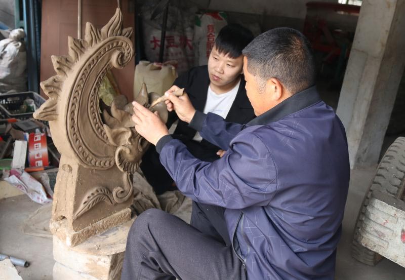 张付龙在传授脊兽捏塑技艺（杨士奎 摄）