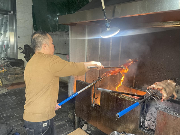 临高烤猪师在乳猪表面涂抹上料（许丽雅 摄）