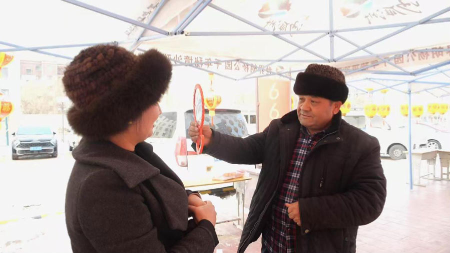 大家正在试戴沙雅卡拉库尔胎羔皮帽（佐合热古丽 摄）