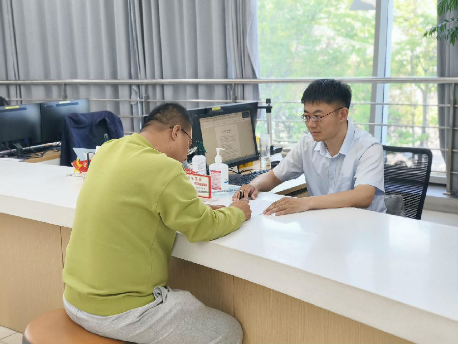 工作人员在指导填报手续（赵瑞超 摄）