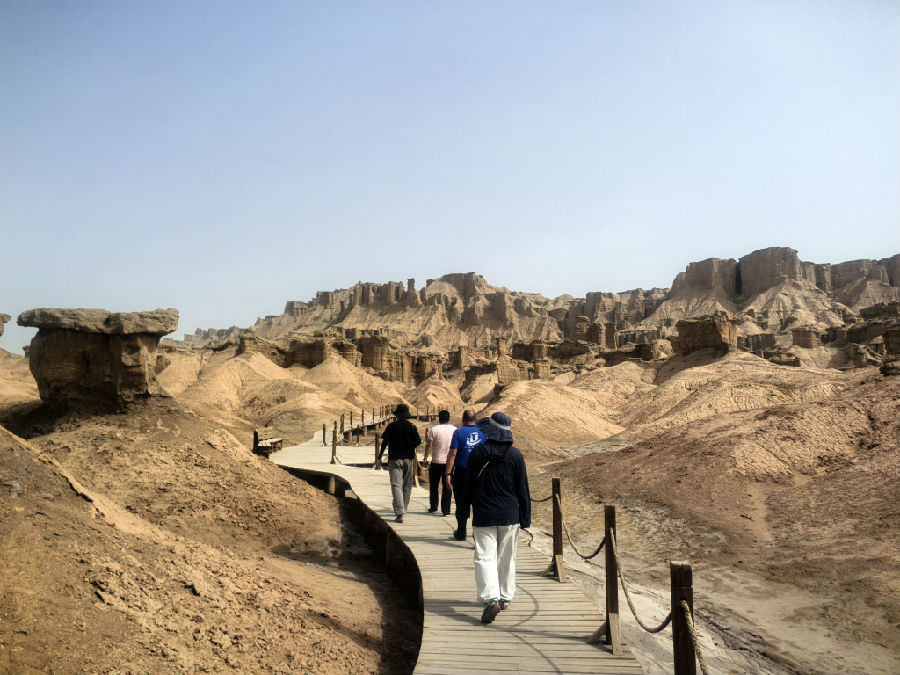 游客沿着木栈道走入克孜尔红石林景区（查燕荣 摄）