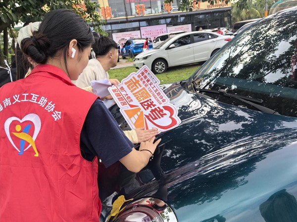 志愿者贴上“爱心送考”车贴（骆金梅 摄）