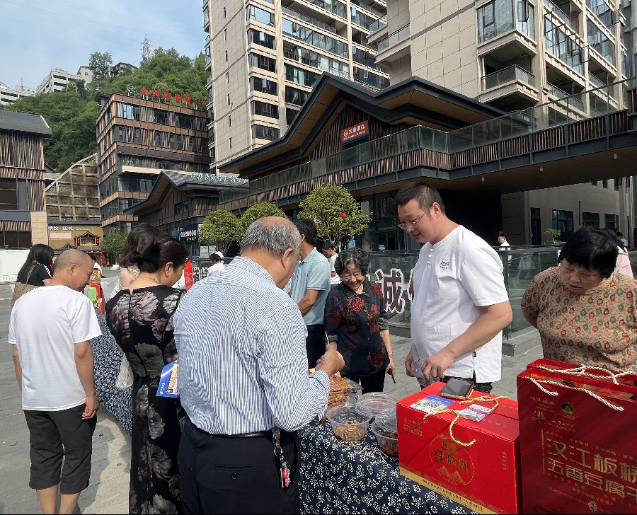 游客选购郧西本地农特产品“板桥豆干”（王洁洁 摄）