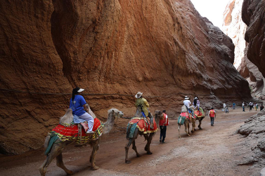 游客在天山神秘大峡谷骑骆驼游玩（歹淑丽摄）