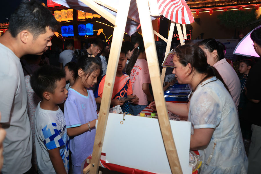 游客使用互动游戏中赢取的“粮票”兑换礼品（李东强 摄）