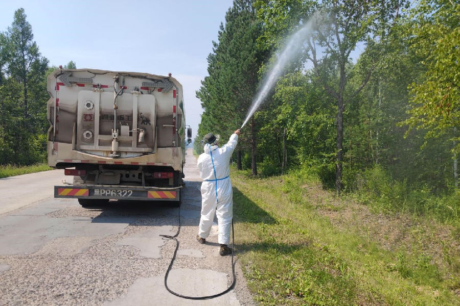 喷药车在对道路沿线林木进行大范围药剂喷洒（于建 摄）