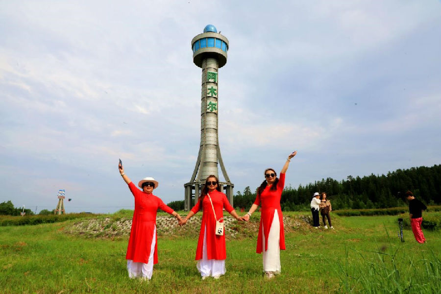 来自黑龙江省大庆市的游客走进阿木尔林业局地标性建筑（王力 摄）