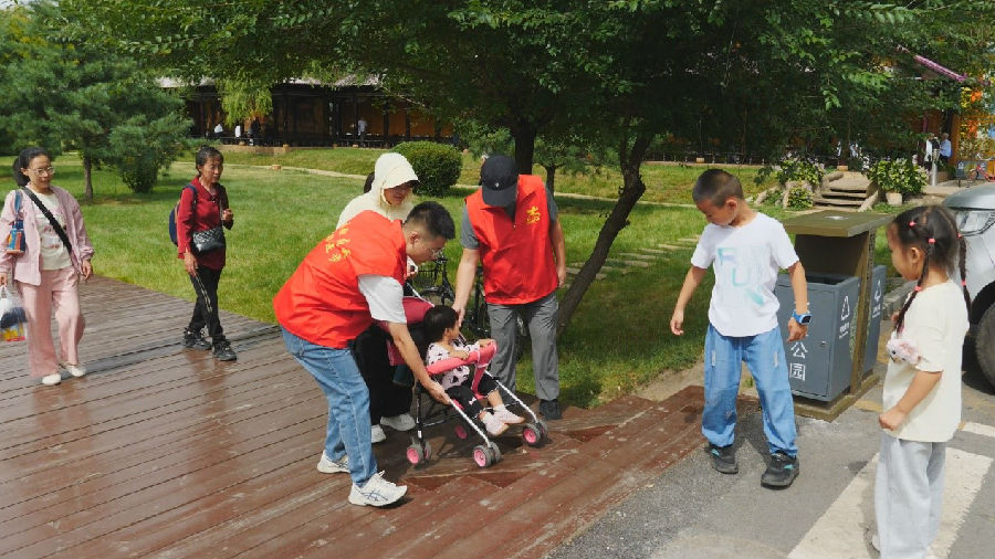 伊美区林都木雕园志愿者服务游客（王文彪 摄）