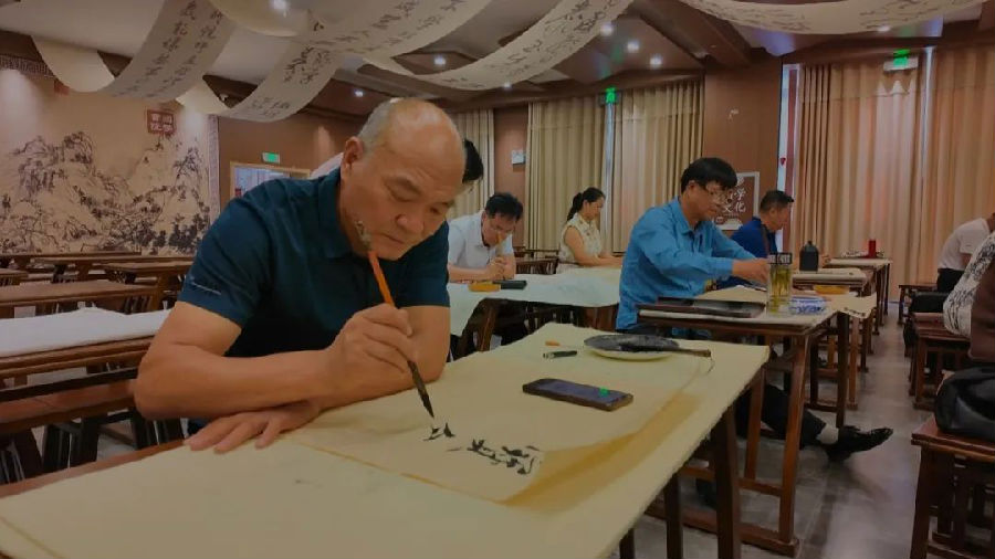 文艺爱好者正在进行书法创作。（王旭 摄）