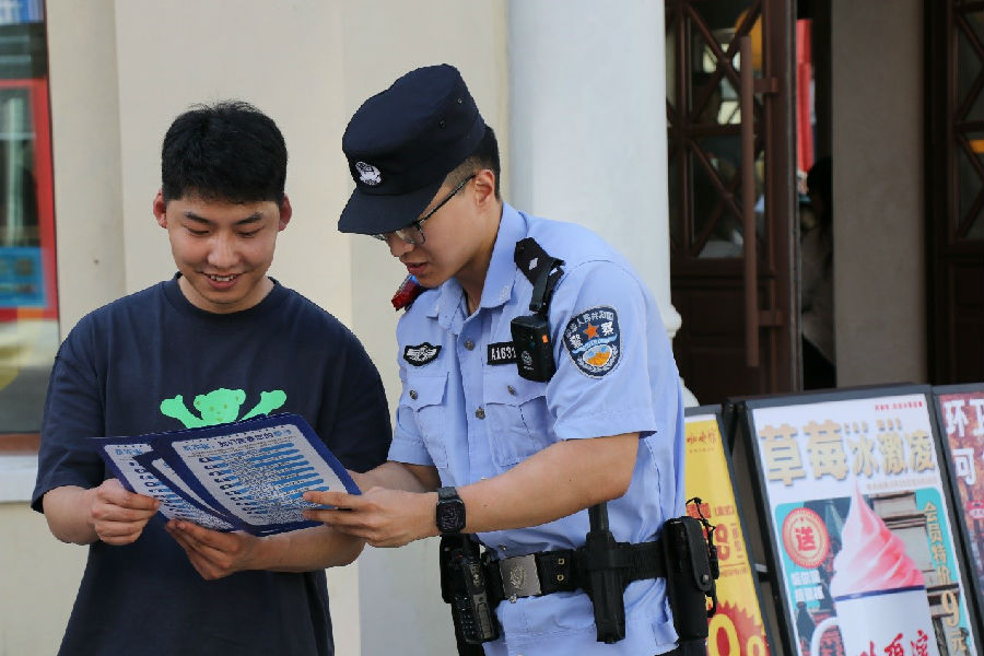 民警手持宣传彩页进行生动宣讲(滕向超 摄) 民警手持宣传彩页进行生动宣讲(滕向超 摄)