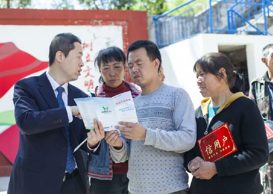 工作人员向农户们发放宣传手册 （郝崧晔 摄）