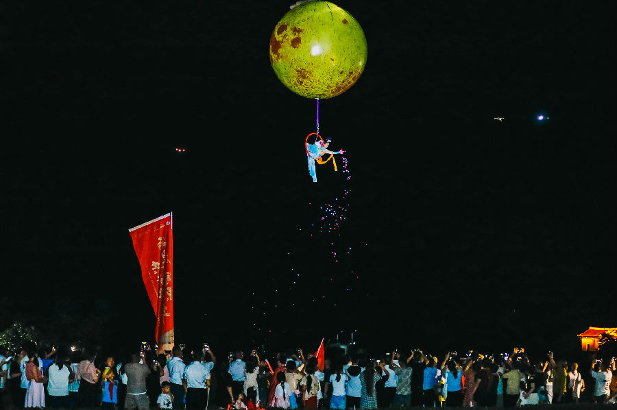 土楼上方进行的“飞天神女”表演吸引游客拍照打卡（唐小玲 摄）