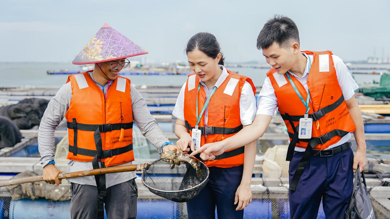 养殖户向客户经理分享丰收的喜悦 （吴诗茵 摄）