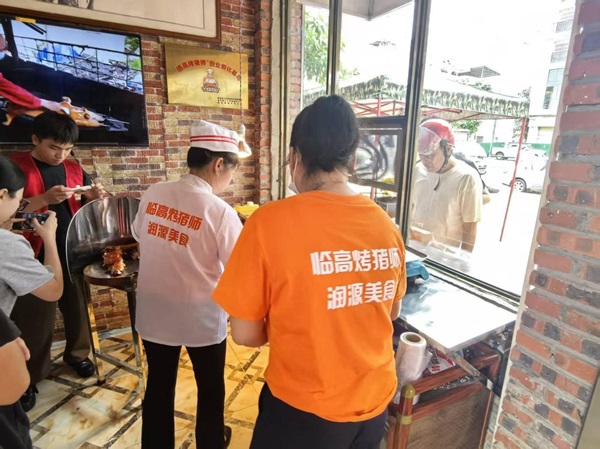 市民凭商务消费券购买烤乳猪（骆金梅 摄）