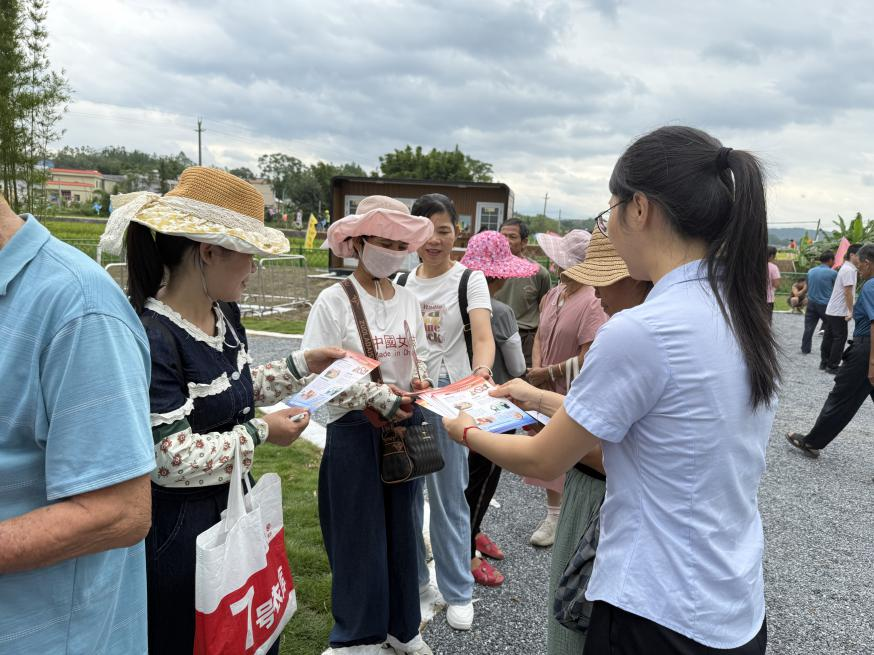 邮储银行新丰县支行客户经理向村民派发金融知识宣传单 （赵师可 摄）