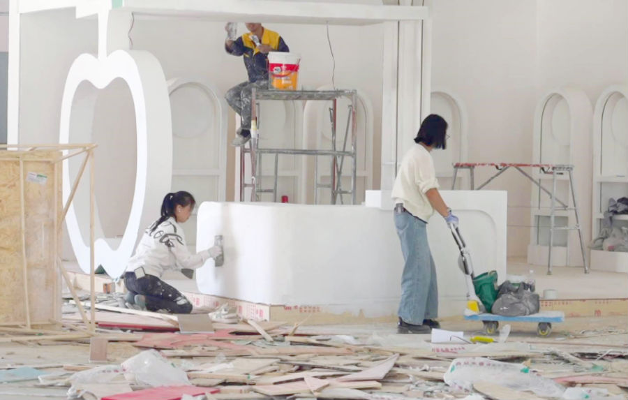 场馆内工人正有条不紊地进行展位搭建与铺设工作。（崔书敏 摄）