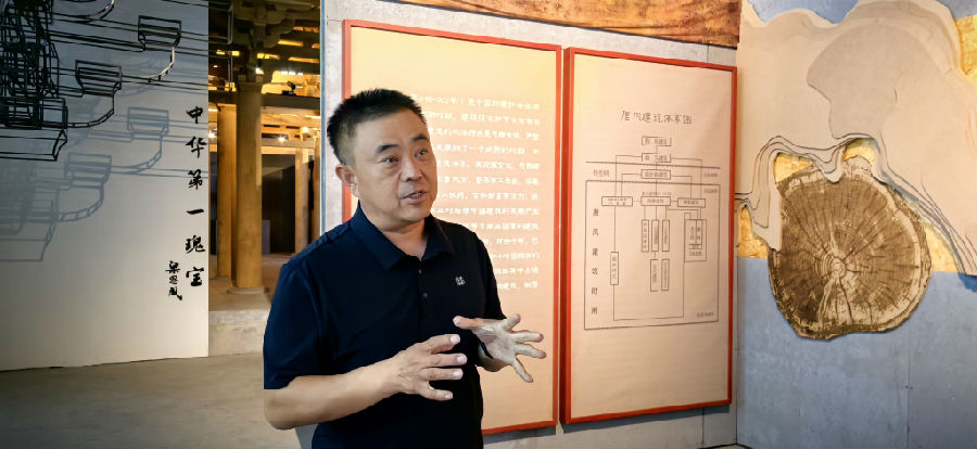 刘晓辰向记者介绍木雕模型背后的工艺与文化传承（席兆平 摄）