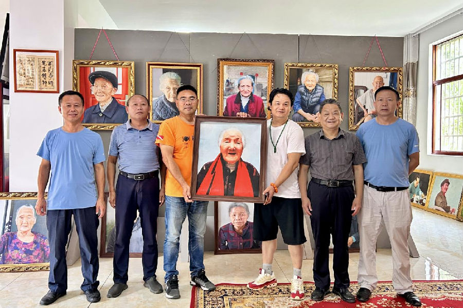 现场与仙岛湖百岁老人画像合影（倪婷婷 摄）
