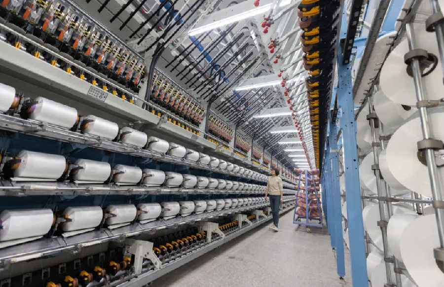湖北天门三圆纺织科技有限公司生产车间，加弹机“吐出”一卷卷锦纶长丝 （田萱 摄）