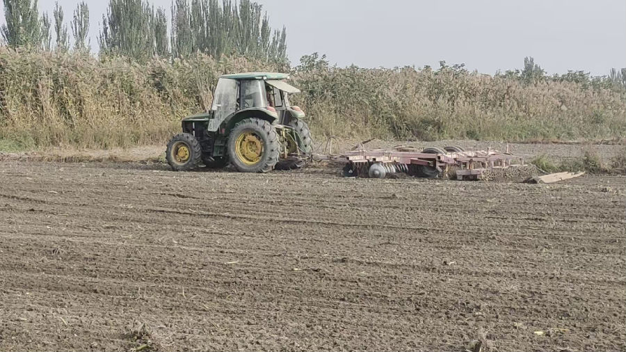 温宿县托甫汗镇托万克托甫汗村村民驾驶农机播种冬小麦（陈强 摄）