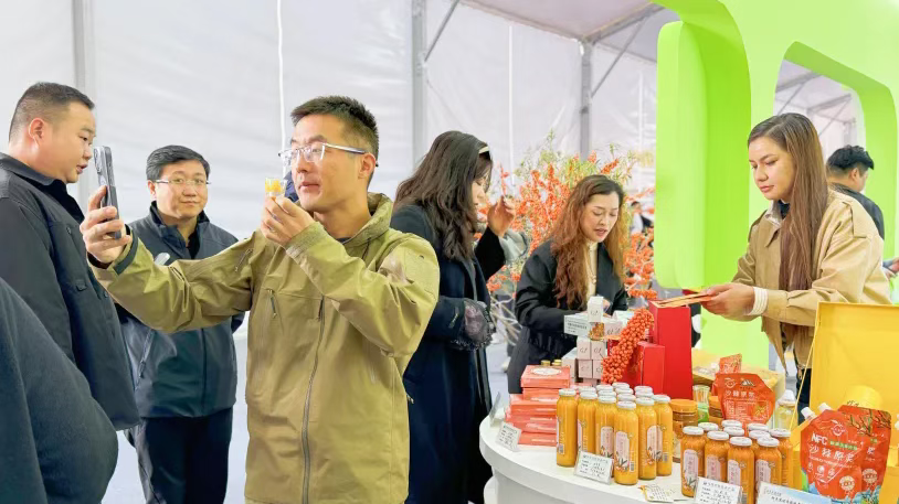 客商们正在展位前品鉴展品、洽谈合作。（张勇 摄）