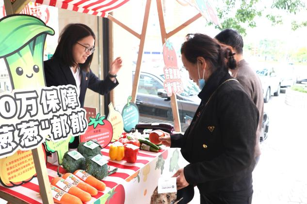 活动将存款保险知识与新鲜蔬菜巧妙融合，助力户外劳动者提升金融素养 （江奕萍 摄）