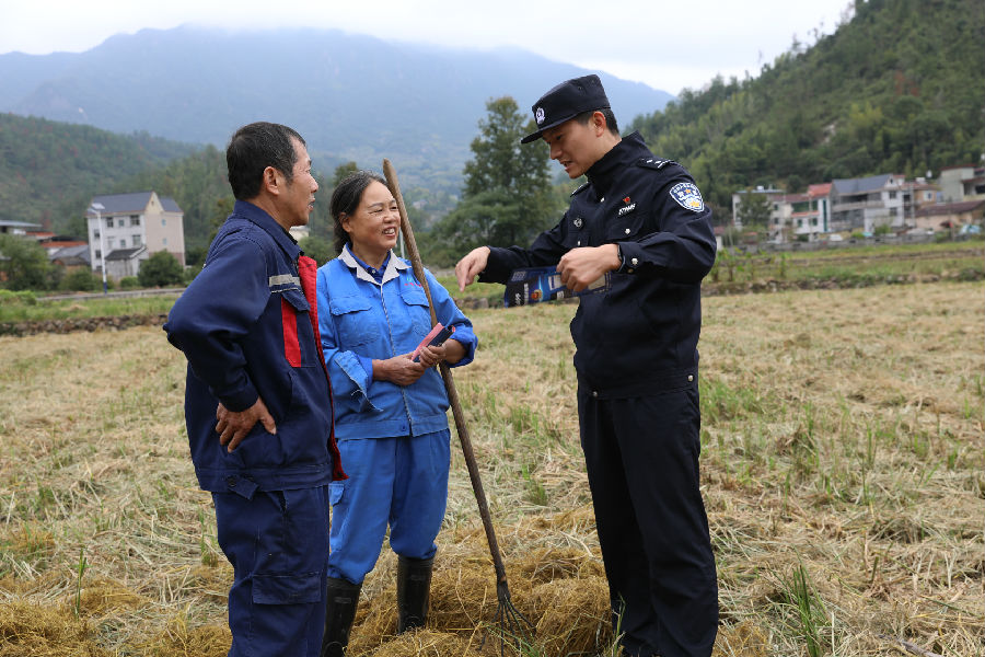 10月24日，云峰派出所民警在田间地头走访群众（胡昌清 摄）