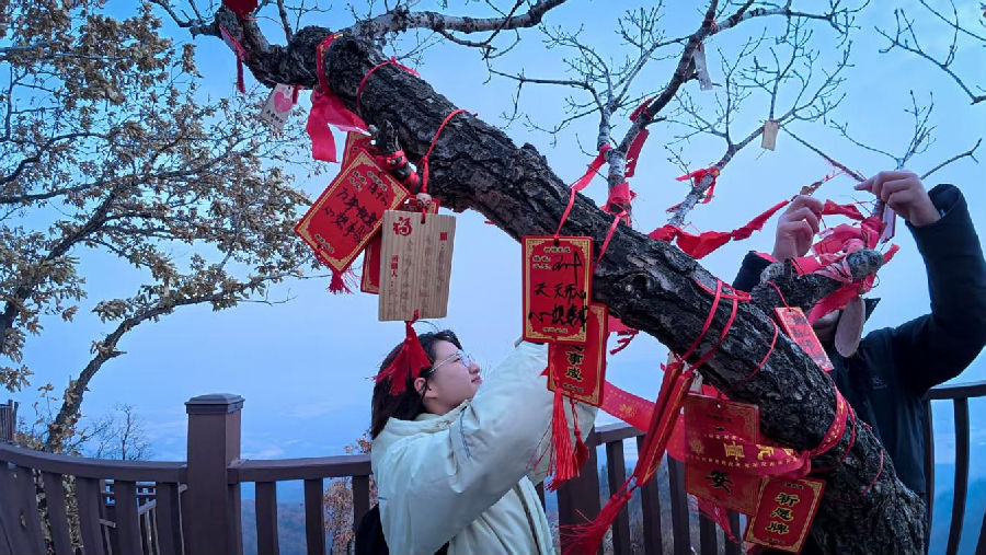 参与者们在心愿牌上写下祝福，悬挂于祈福长廊。（徐秀红 摄）