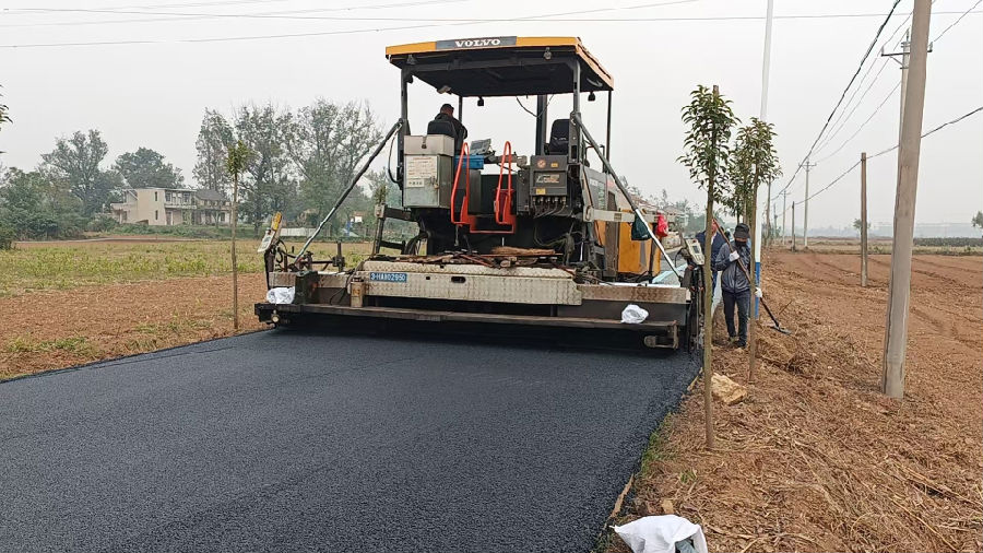 工人正在使用摊铺机把路压实（李游 摄）