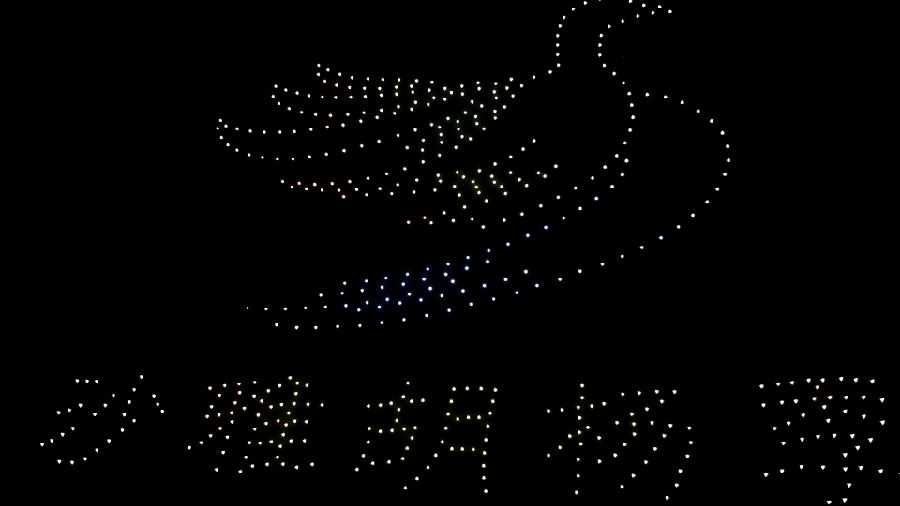无人机在夜空中闪烁交错，依次变换出五星红旗、我爱中国、我爱沙雅等精彩画面。（柴梦乐 摄）