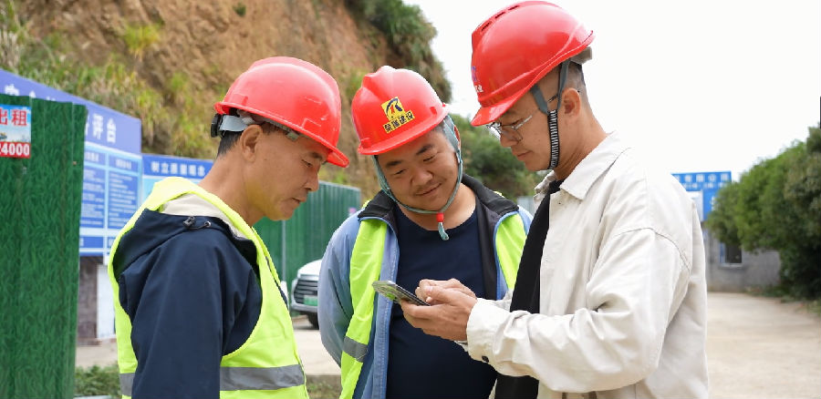 浙江荣瑞建设有限公司工作人员徐德志（右）正登录“农民工工资专用账户线上办理系统”（葛锦熙 摄）