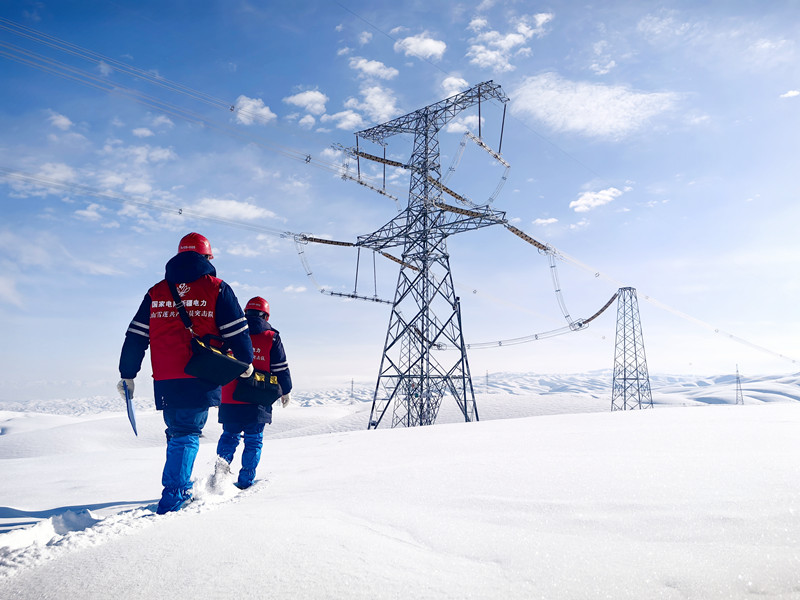 新疆送变电有限公司员工蹚雪巡视750千伏伊库线。(马赟广 摄) 新疆送变电有限公司员工蹚雪巡视750千伏伊库线。(马赟广 摄)