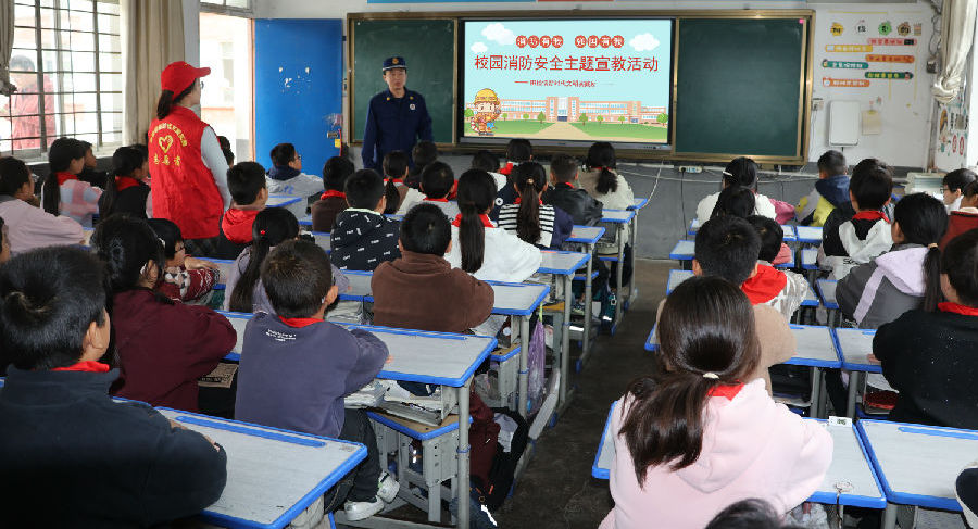 消防救援大队队员正在给学生普及消防知识（王华 摄）