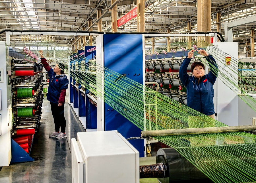 在乐陵泰山人造草坪产业有限公司生产车间，工人们在赶制订单。（贾鹏 摄）