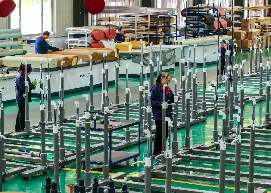 在山东泰山体育器材有限公司生产车间，工人们在组装双杠。（贾鹏 摄）