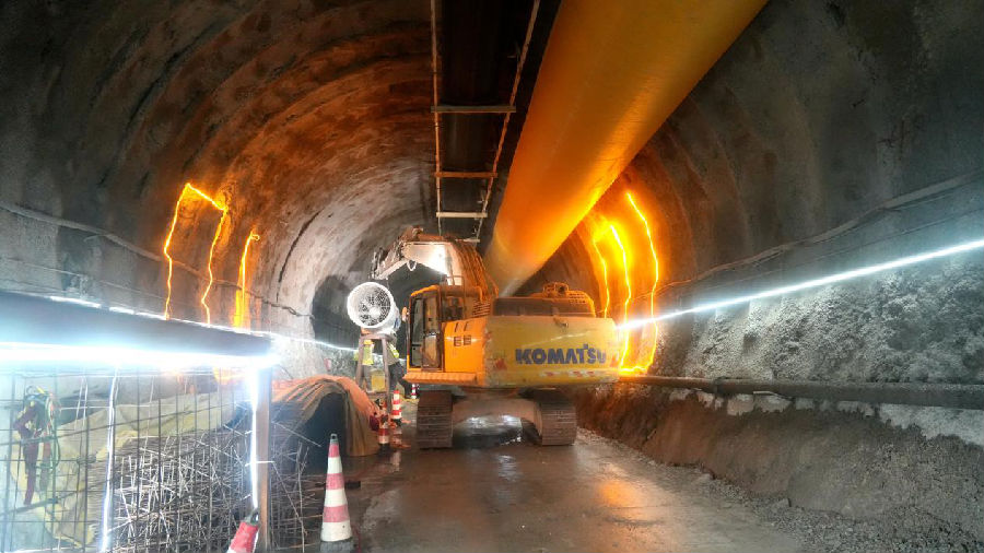 在新疆G219昭苏至温宿公路EPC-2标段西天山特长隧道平导洞内，工人给洞内安装风机（赵新昌 摄）