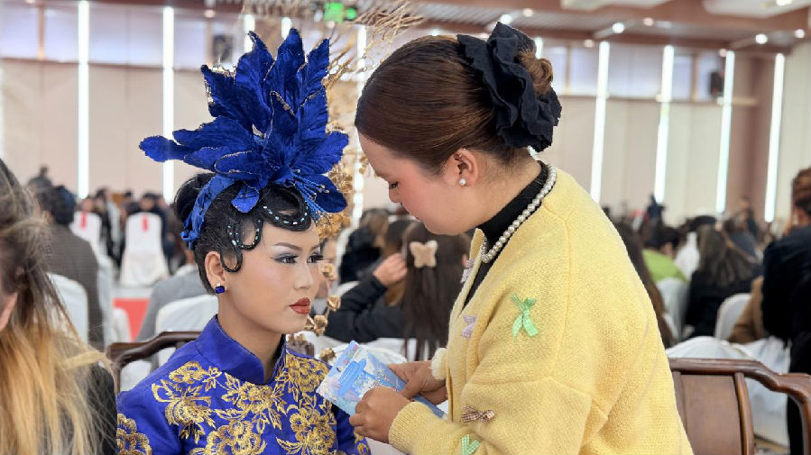 化妆师为模特打造美妆造型，尽显专业技艺与创意。（祖丽皮耶 摄）