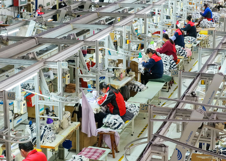 在艾图爱制衣（艾图爱制衣乐陵生产基地）乐陵生产基地企业车间，工人们在赶制运动服装订单。（贾鹏 摄）