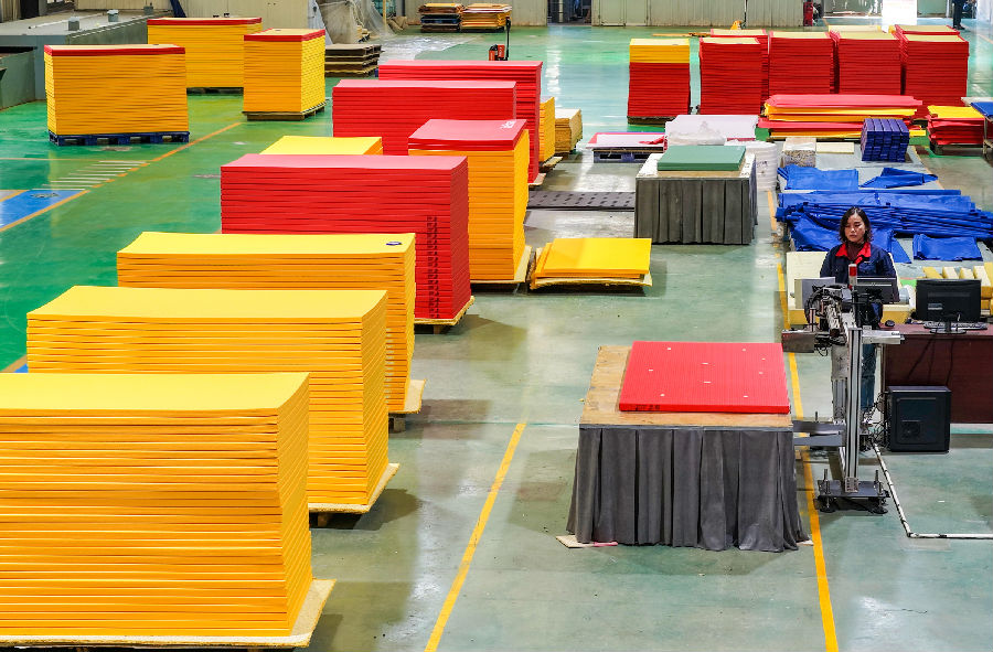 在山东泰山体育器材有限公司生产车间，工人们在赶制体操垫。（贾鹏 摄）