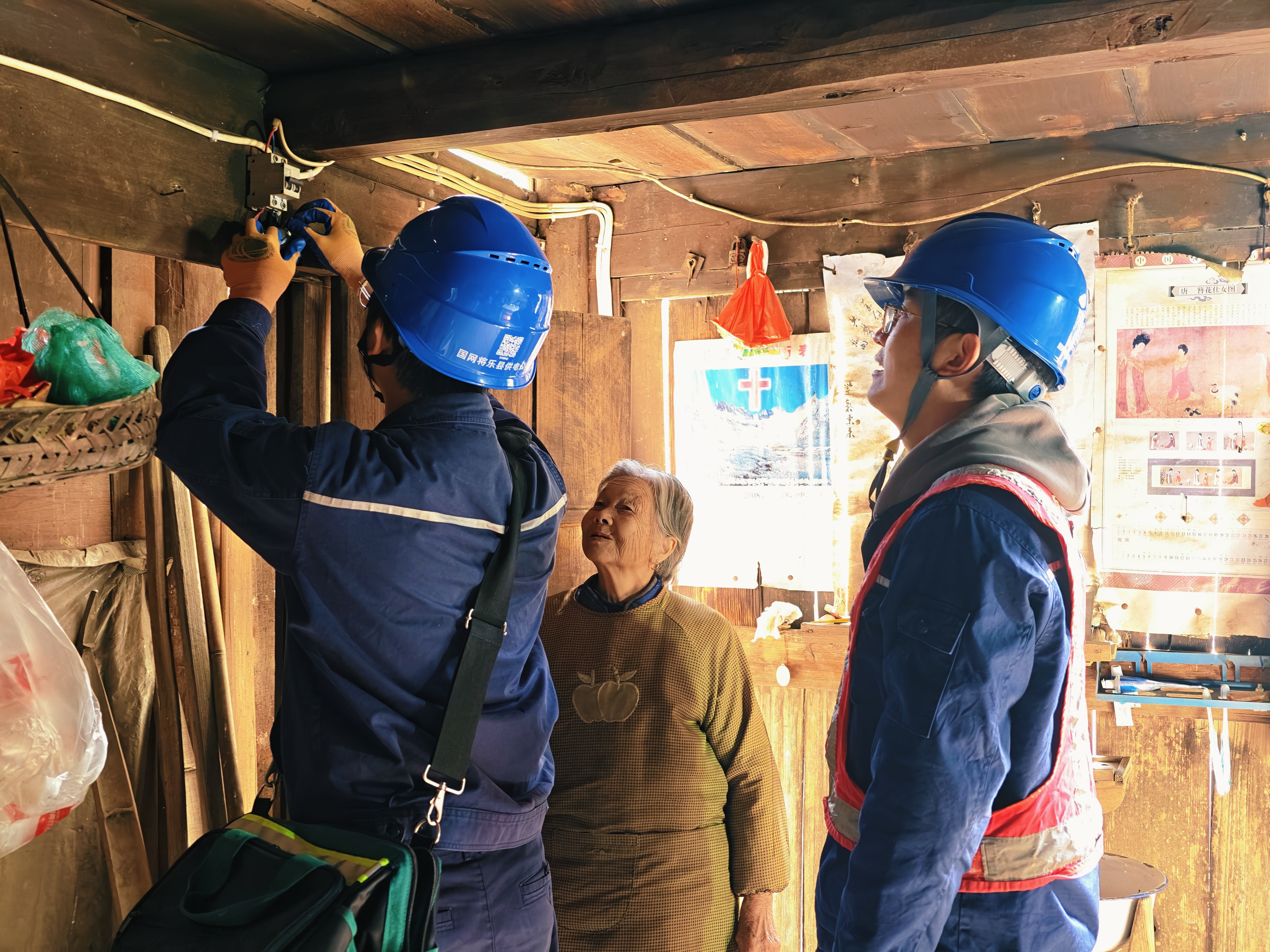 11月19日,国网将乐县供电公司员工吴建聪、林诗锐走进安仁乡乡村民居宅院,为老人们义务检查户内线路和用电插座,面对面讲解电气火灾应急处理注意事项,护航老人温暖过冬。(吴小云 摄)