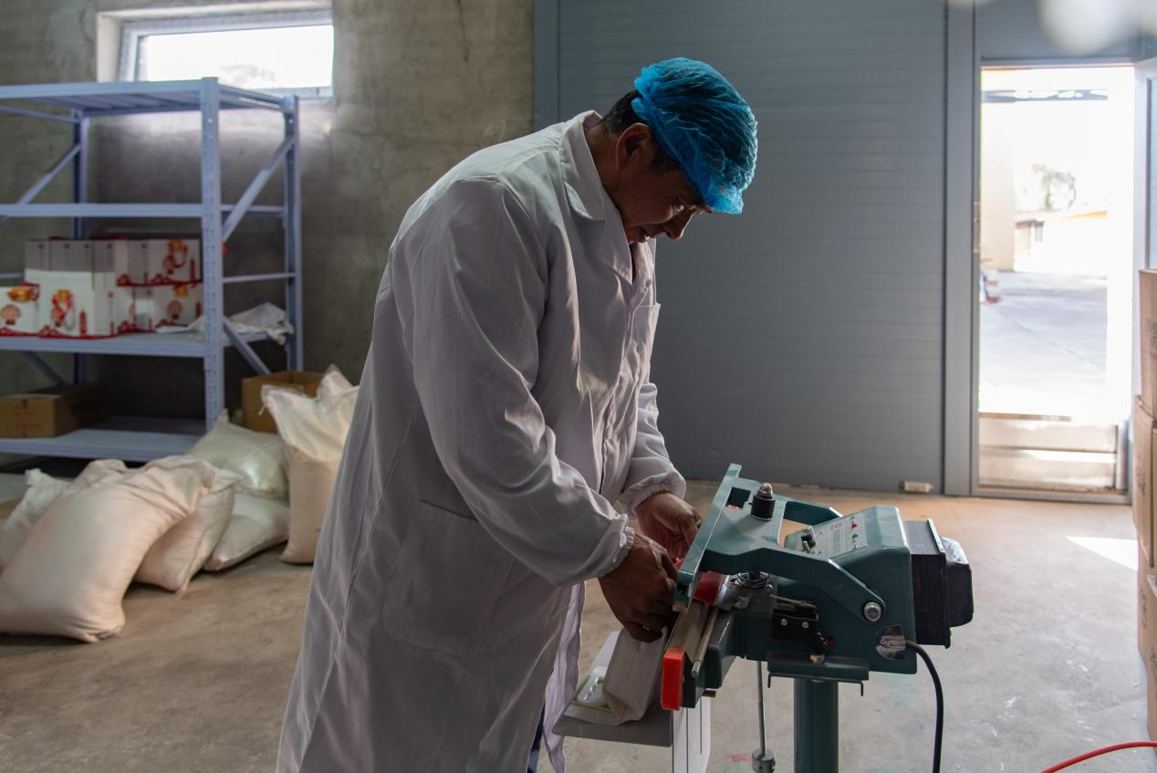 工人在对农产品进行封装加工(楚向东 摄)