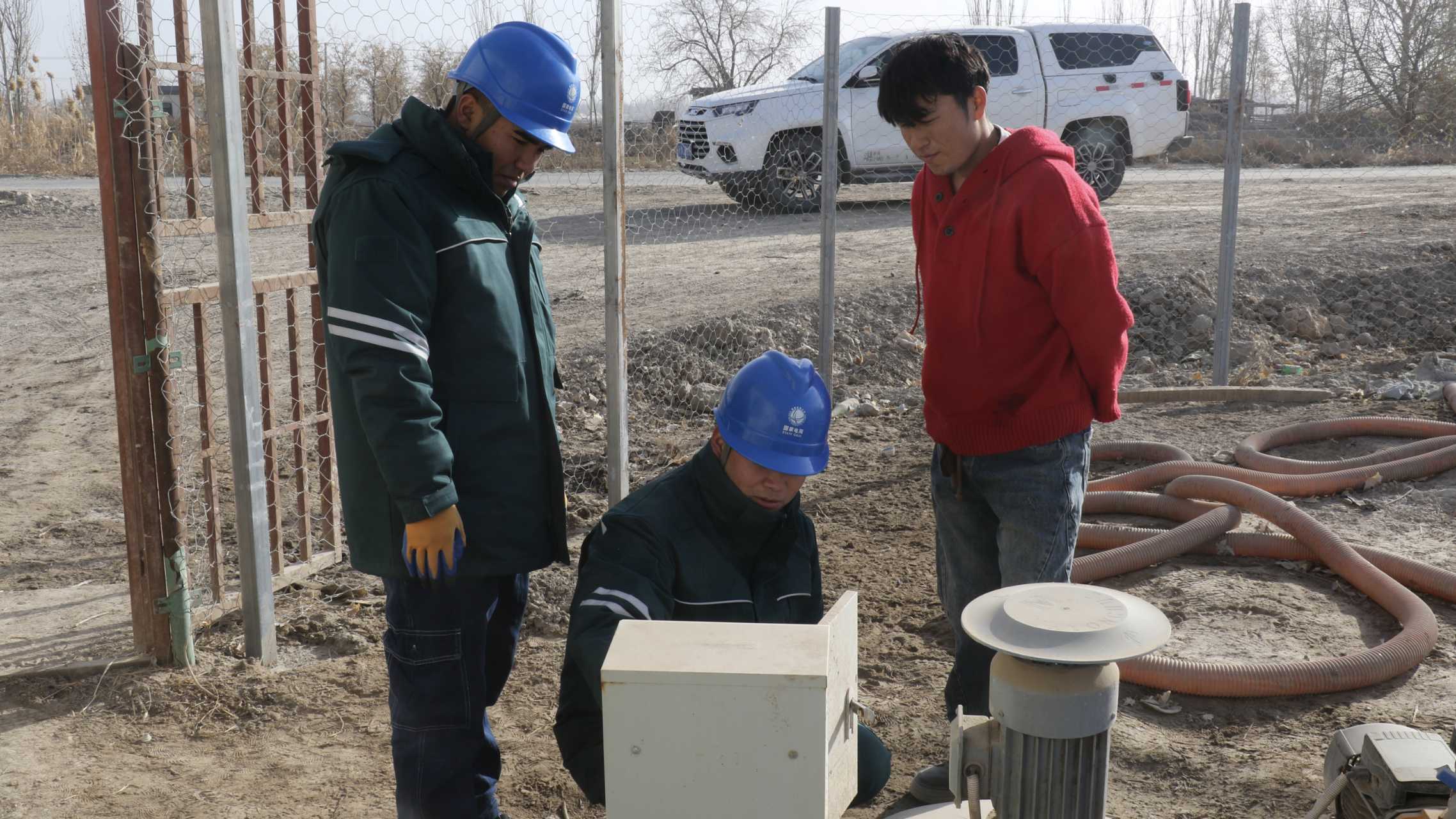 英买力镇供电所员工深入田间地头,现场提供专业技术支持与服务。(王水江 摄)