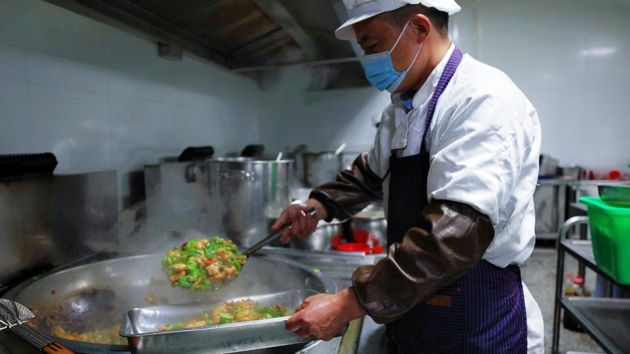 南漳县第一高级中学的家长厨师正在烹饪美食(龚良杰 摄)