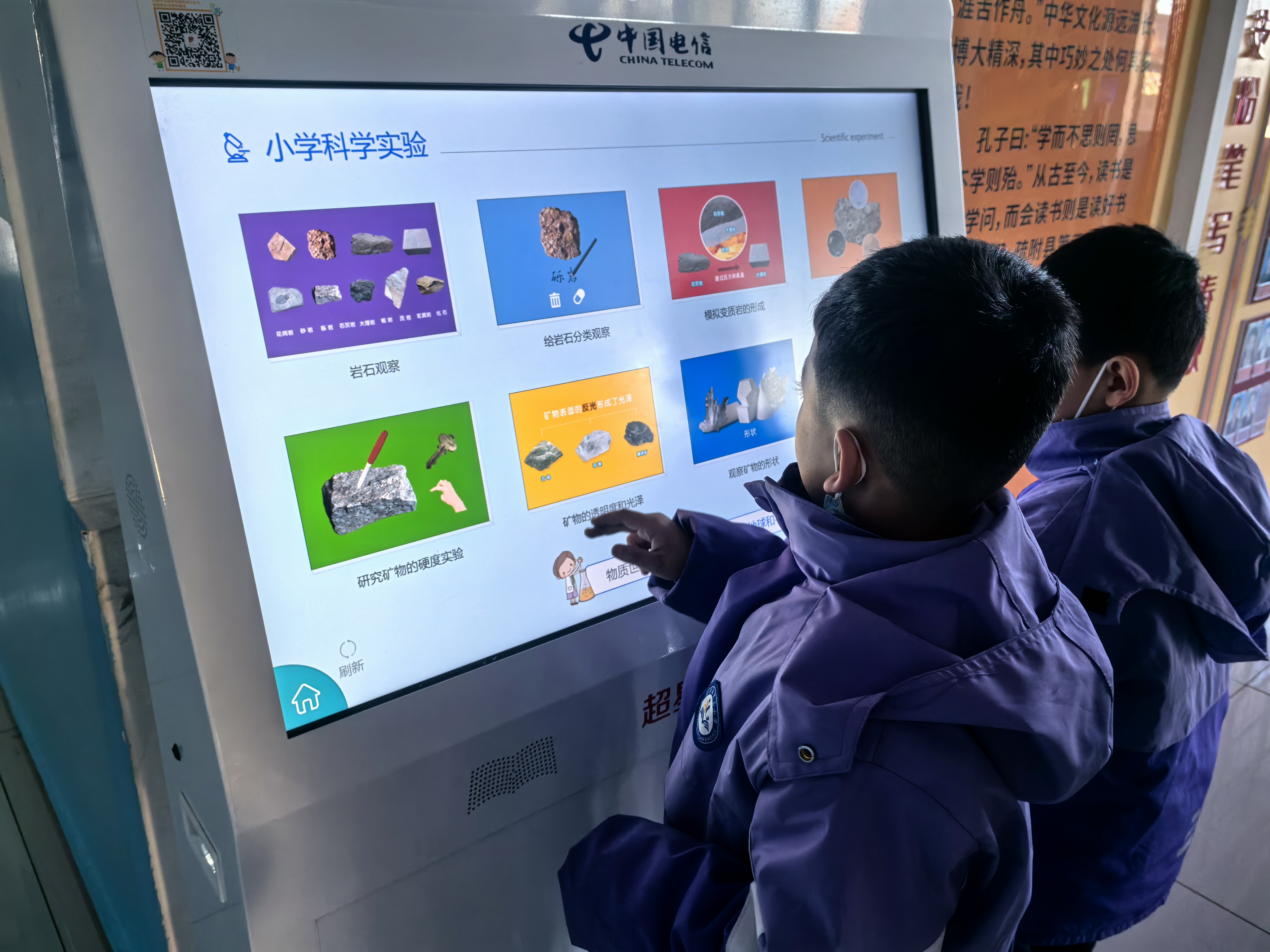 孩子们利用课间时间在阅读机上学习科学实验等知识(查燕荣 摄)