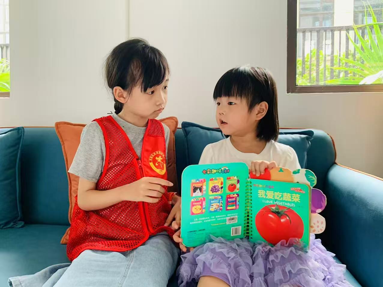 姚静安小朋友正在为小妹妹讲绘本(陈玉师 摄)